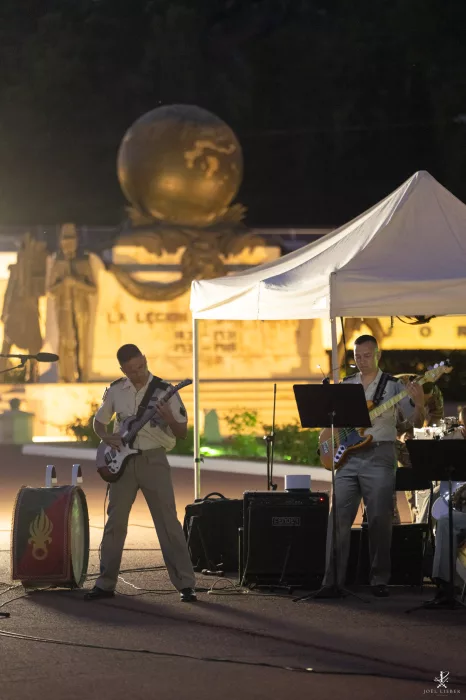 Musiciens de la Légion étrangère jouant de la guitare et de la basse devant le monument aux morts.