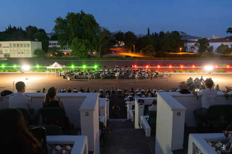 Vue d’ensemble du concert des deux légions au crépuscule devant le public.